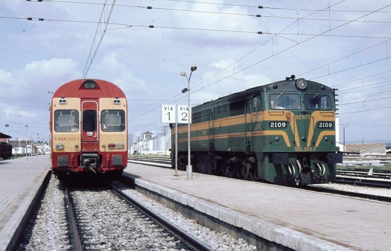 e12 Camino de las vías del sur, un rápido electrotren 444 se cruza con la 2109, plácidamente estacionada, a principios de los 80 en Espeluy.jpg