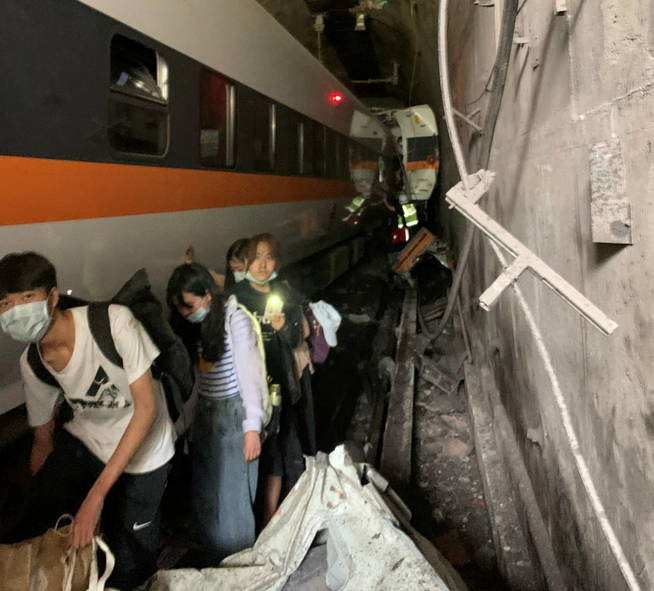 people-walk-next-to-a-train-which-derailed-in-a-tunnel-north-of-hualien-taiwan-april-2-2021-in-this-handout-image-provided-by-...national-fire-agency-handout-via-reuters-attention-editors-this-image-was-provided-by-a-third-party-no-resales-no-archives.jpg