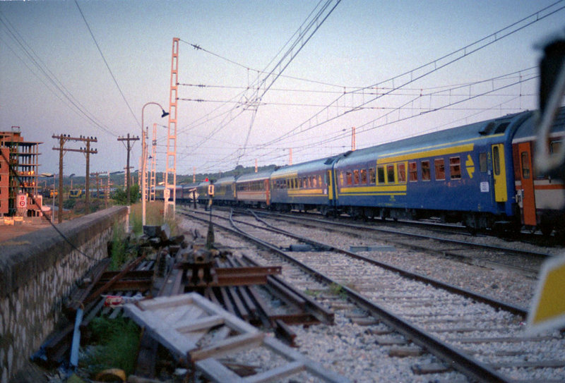 e170 Sitges, 8-8-88. De buena mañana, a las 7'25 el Torre del Oro deja Sitges con un tren larguísimo, cruzandose an la señan de entrada sur, con el Estrella Ciudad Condal..jpg